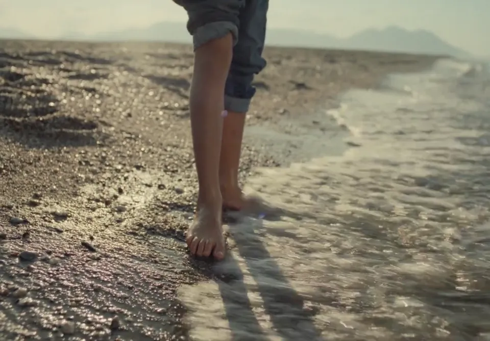Still from a dockyard commercial: bare feet on a beach